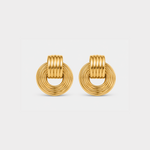 A pair of gold-toned hoop earrings with a textured, ridged circular design, shown on a light gray background.